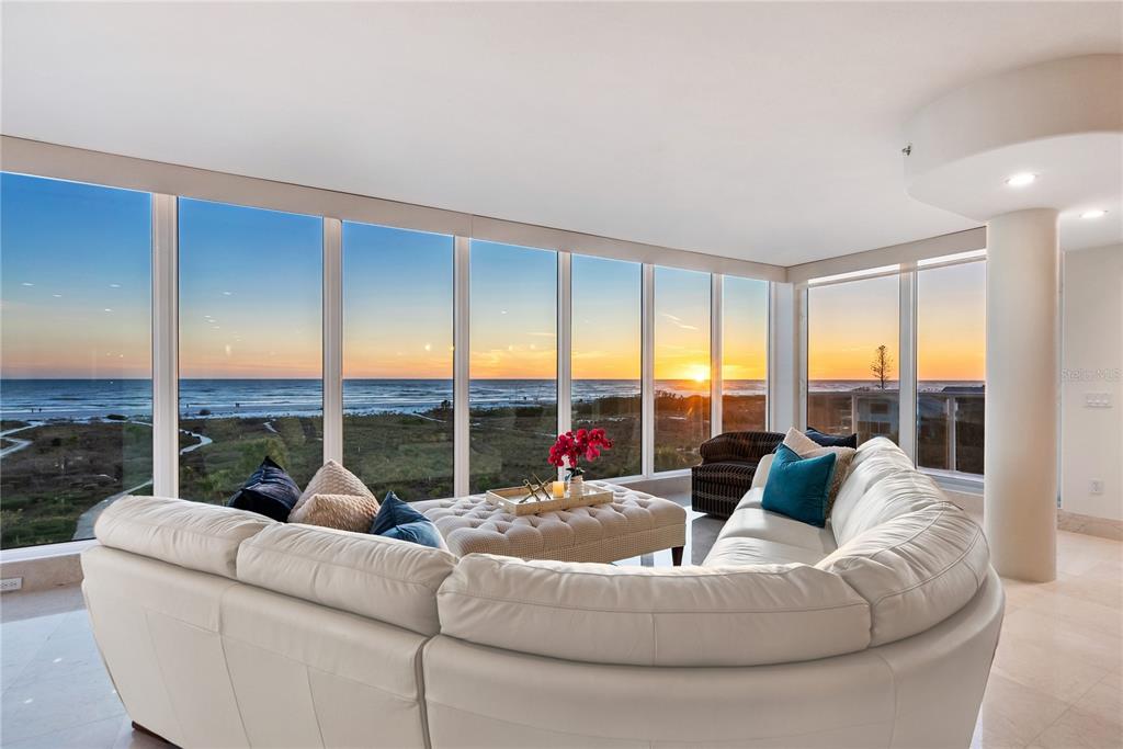 A patio with a round table and chairs overlooks the ocean at sunset — 534 BEACH ROAD, SARASOTA, FL