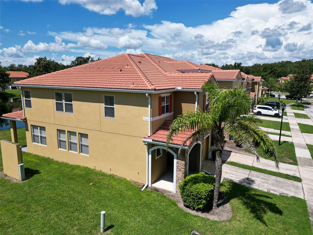 An aerial view of a two-story tan stucco townhouse with a red tile roof — 3064 SEAVIEW CASTLE DRIVE, KISSIMMEE, FL