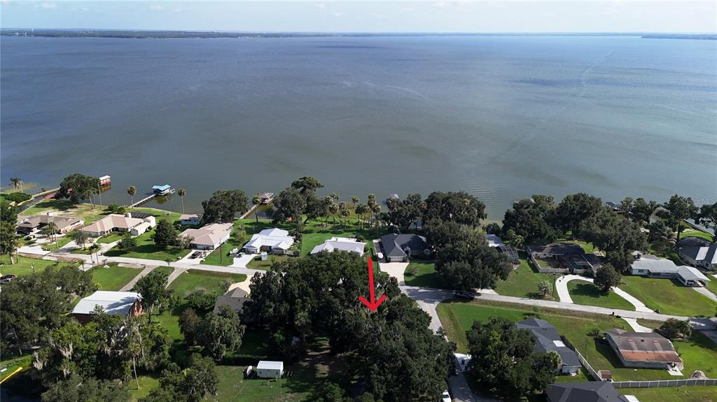 An aerial view shows a residential neighborhood situated along the shore of a large lake — LAKESIDE DRIVE, YALAHA, FL