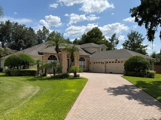 A single-story house with a stone facade, a paved driveway, and a parked silver SUV — 13856 GLYNSHEL DRIVE, WINTER GARDEN, FL