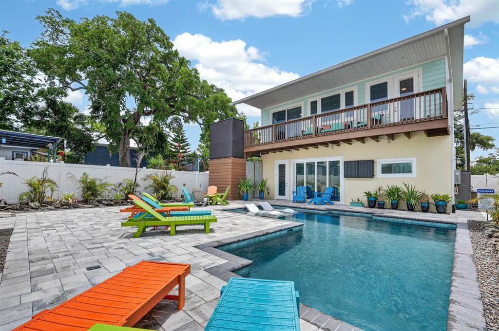 A two-story light blue house with a covered front porch and a yellow front door — 204 PALMETTO STREET, NEW SMYRNA BEACH, FL
