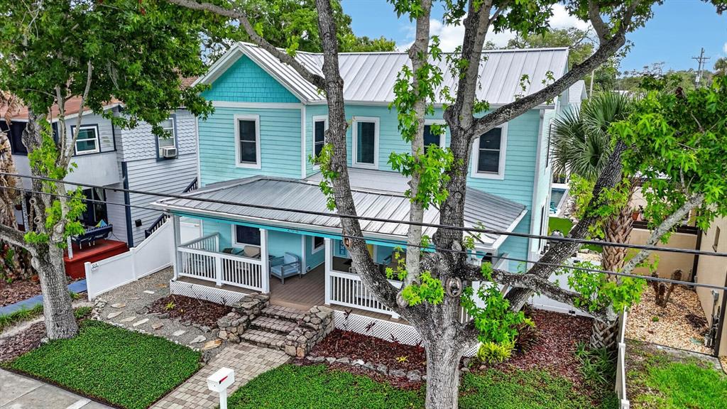 A light blue two-story house features a front porch, white railings, and a yellow door — 204 PALMETTO STREET, NEW SMYRNA BEACH, FL