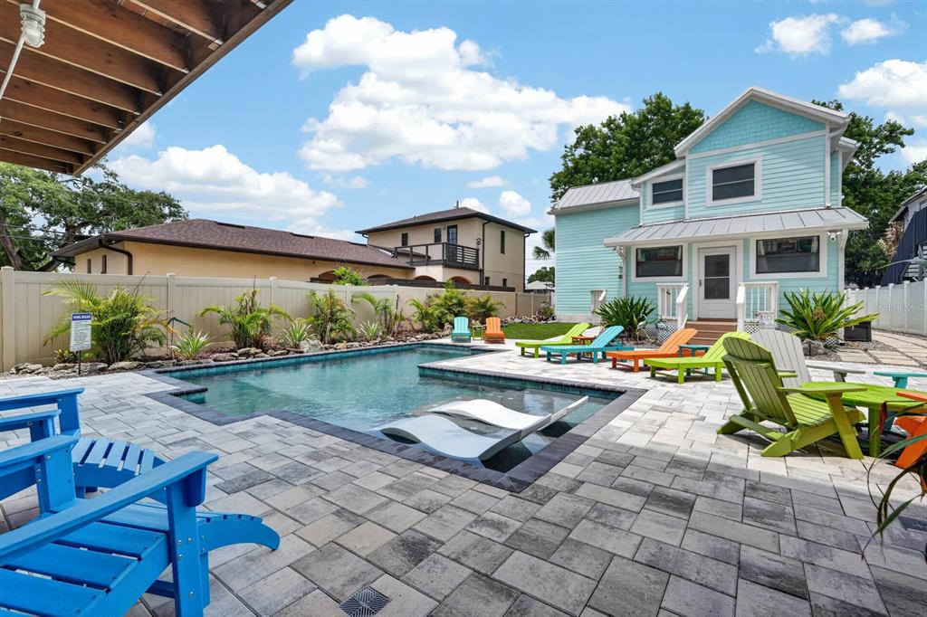 A light blue two-story house with a front porch sits behind a sidewalk and trees — 204 PALMETTO STREET, NEW SMYRNA BEACH, FL