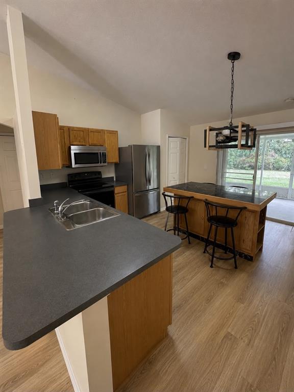 A kitchen features dark countertops, wood cabinets, stainless steel appliances, and a central island — 2743 SOMERSET, PALM BAY, FL
