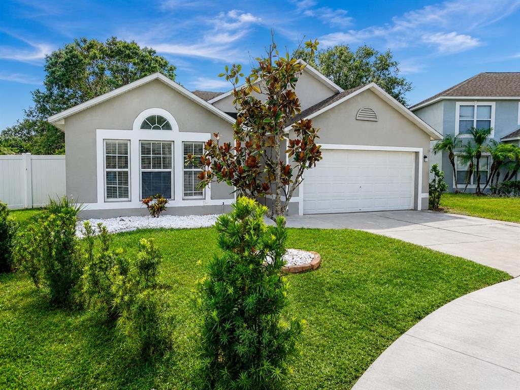 A single-story house with a gray exterior, a two-car garage, and a front lawn — 13402 COPPER HEAD DRIVE, RIVERVIEW, FL