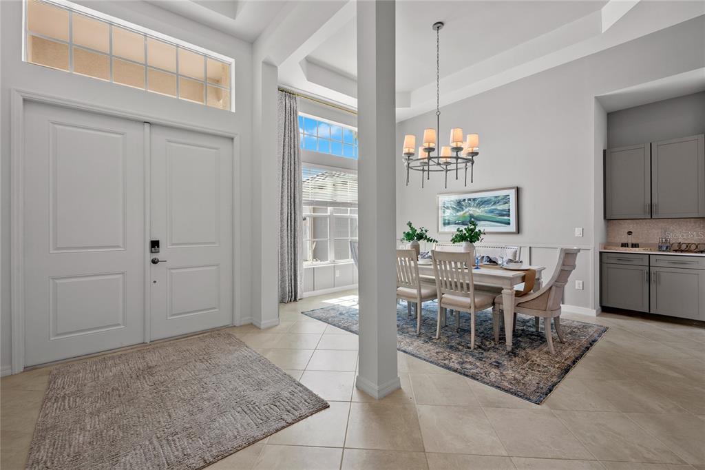 A dining room with a chandelier, table, chairs, and a nearby wet bar area — 20013 TROUT TERRACE, LAKEWOOD RANCH, FL