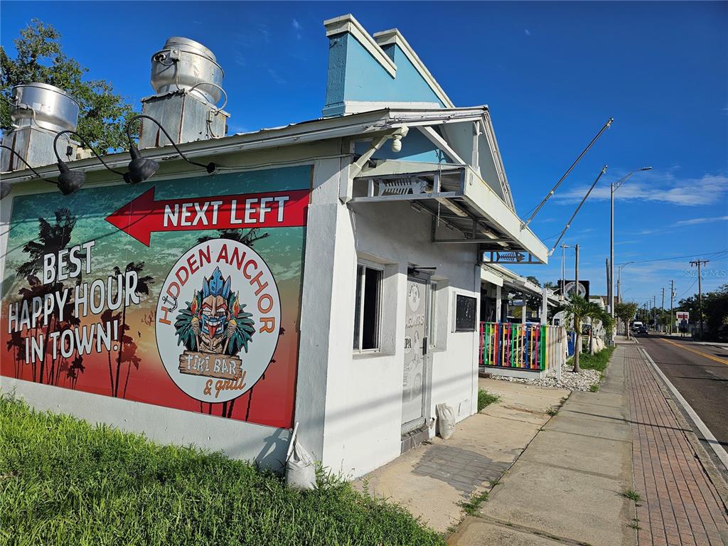 The exterior of a white building features a large mural for a tiki bar and grill — 606 N PINELLAS AVENUE, TARPON SPRINGS, FL
