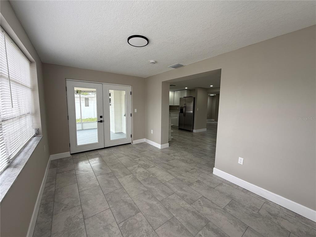 A single-story house with a stone facade, white chimney, and a concrete driveway — 3019 LLOYD DRIVE, HOLIDAY, FL