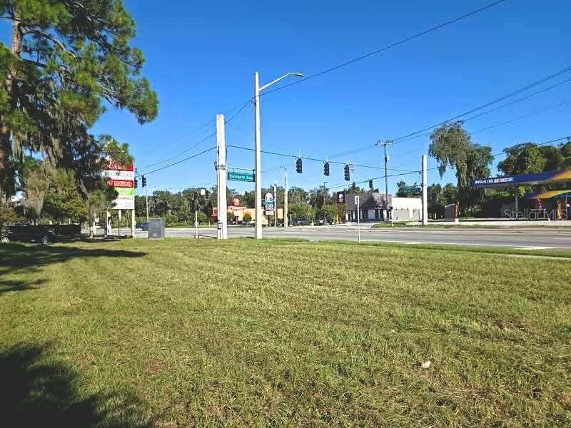 A grassy lot sits in front of a road intersection with traffic lights and businesses — 162 S US HIGHWAY 17, EAST PALATKA, FL