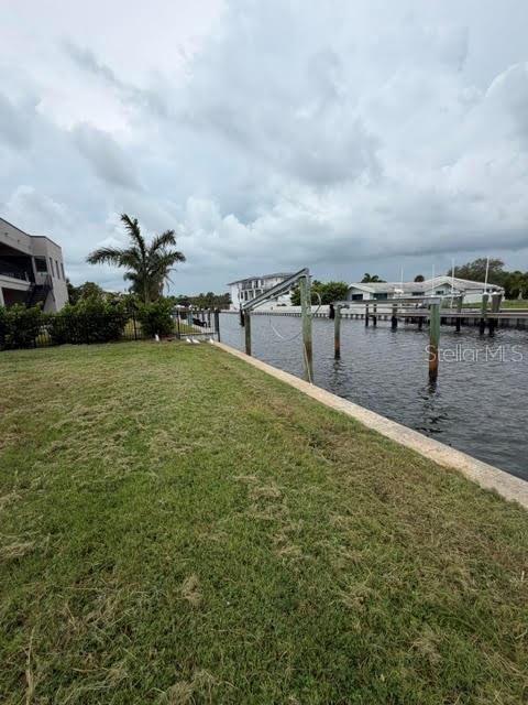 An aerial view shows a vacant waterfront lot situated between two modern residential homes — 581 ROUNTREE DRIVE, LONGBOAT KEY, FL