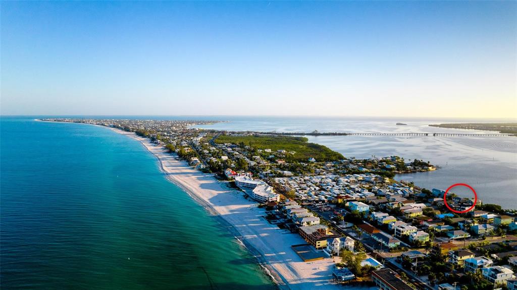 An aerial view of a coastal town with a red circle highlighting a specific property — 2512 AVENUE A, BRADENTON BEACH, FL