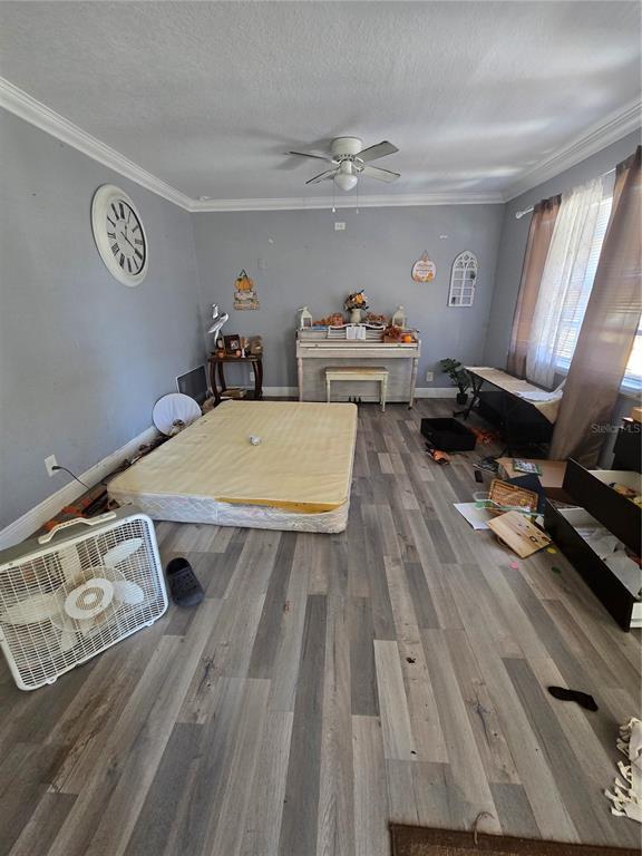 A room with gray walls, wood-look flooring, a box spring on the floor, and a piano — 125 EDGEWATER DRIVE, WINTER HAVEN, FL