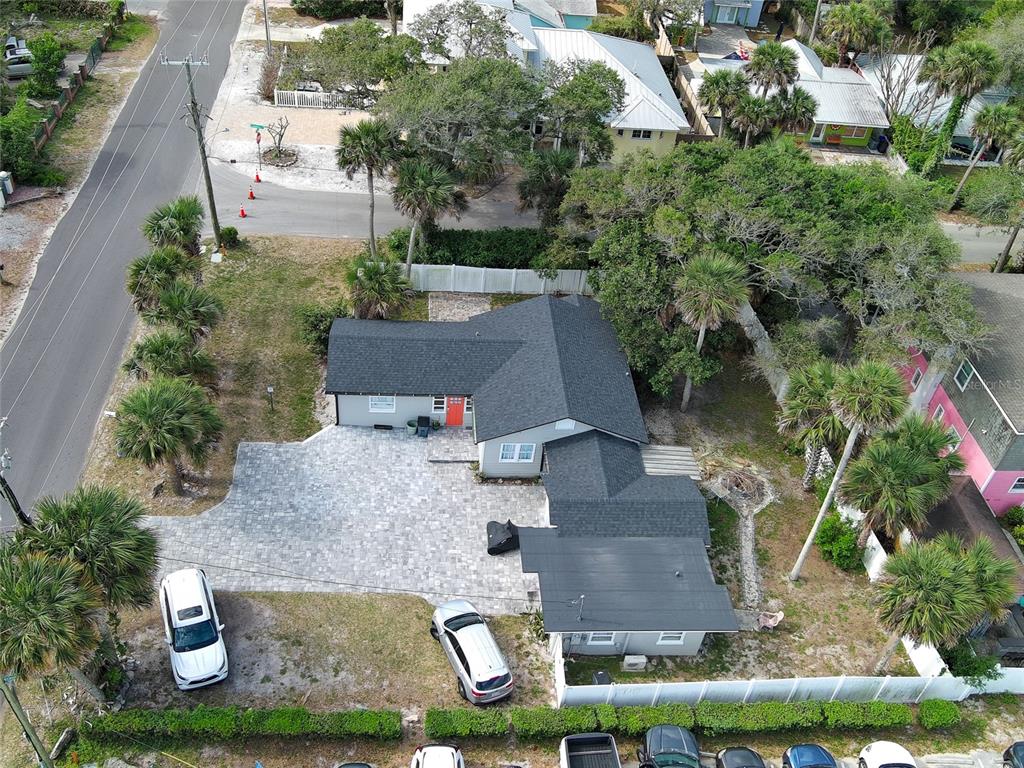 An aerial view shows a coastal town with a red-outlined property near tennis courts — 200 S PINE STREET, NEW SMYRNA BEACH, FL