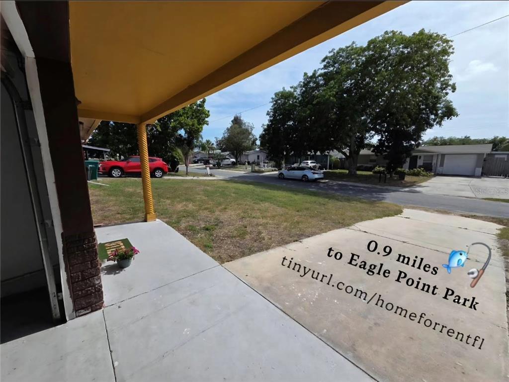 A view from a covered porch looking out toward a residential street and neighboring houses — 4645 IRENE LOOP, NEW PORT RICHEY, FL