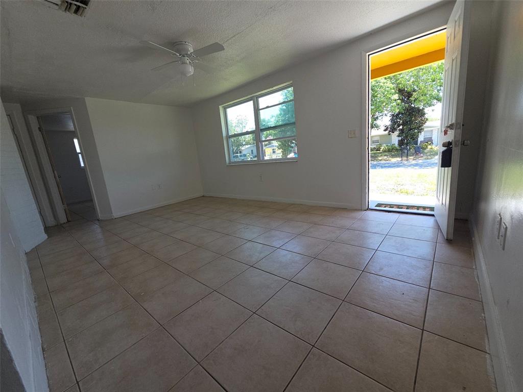 A brown exterior wall with a concrete porch, a yellow support column, and a doorway — 4645 IRENE LOOP, NEW PORT RICHEY, FL