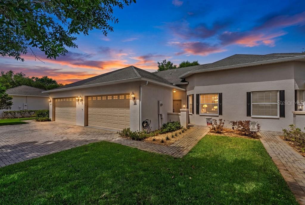 A single-story house with a beige garage door, light stucco walls, and a paver walkway — 1016 GREEN GATE BOULEVARD, GROVELAND, FL