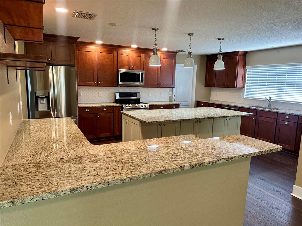 A spacious living area features vaulted ceilings, dark wood flooring, and a ceiling fan — 531 HEARTHGLEN BOULEVARD, WINTER GARDEN, FL