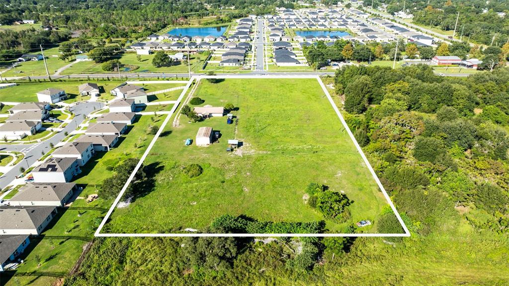 An aerial view shows a large, rectangular grassy lot with a house and outbuildings — 4125 HICKORY TREE ROAD, ST CLOUD, FL