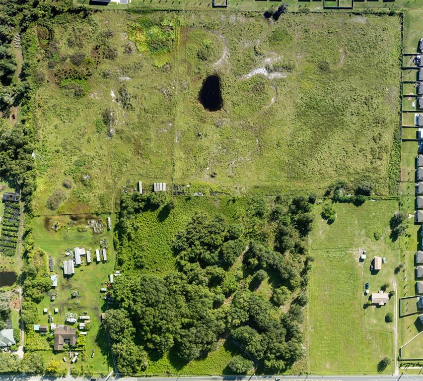 This aerial view shows a large, mostly undeveloped plot of land with a central sinkhole — 4125 HICKORY TREE ROAD, ST CLOUD, FL