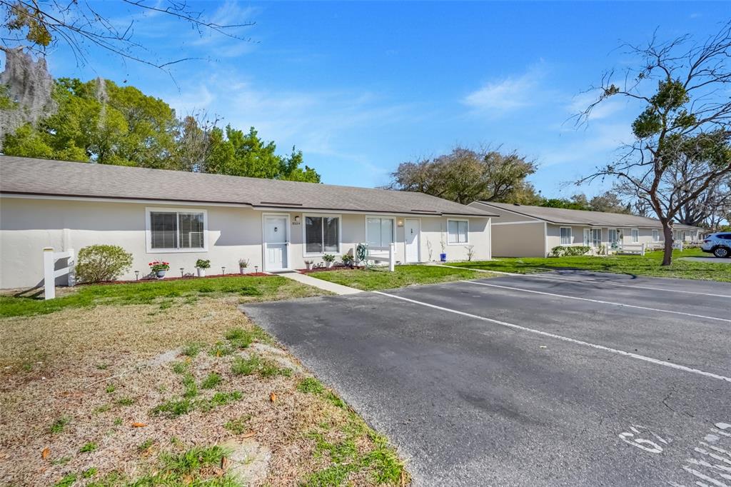 A single-story apartment building with a parking lot in front under a blue sky — 30024 TAVARES RIDGE BOULEVARD UNIT 62, TAVARES, FL