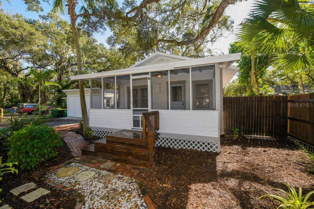 A small white cottage with a screened-in front porch and wooden steps in a yard — 1230 35TH STREET, SARASOTA, FL