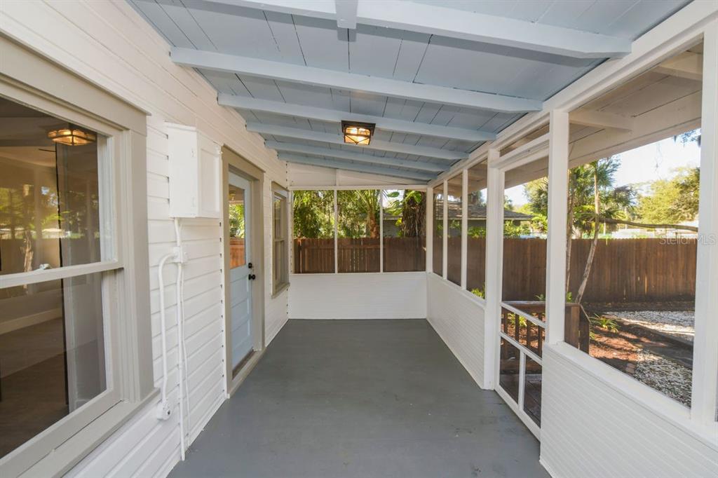 A screened-in porch with a gray floor, light blue ceiling, and white wood siding — 1230 35TH STREET, SARASOTA, FL