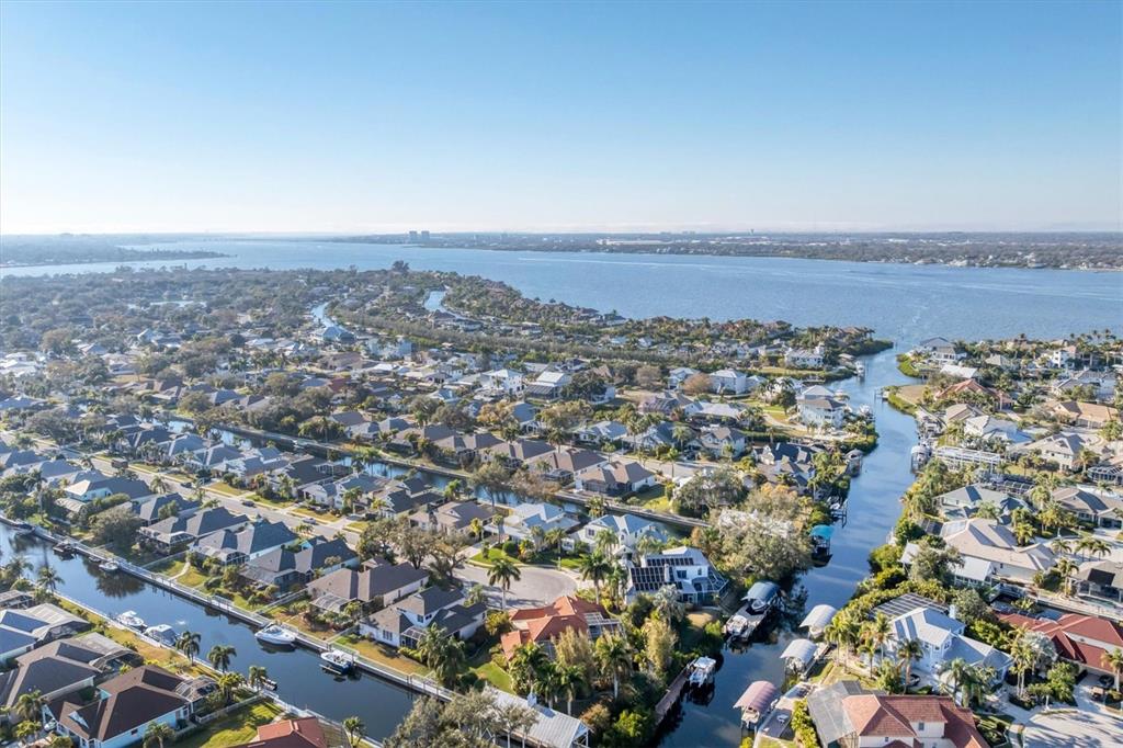 An aerial view of a residential neighborhood featuring houses with metal roofs near water — 4627 BARRACUDA DRIVE, BRADENTON, FL