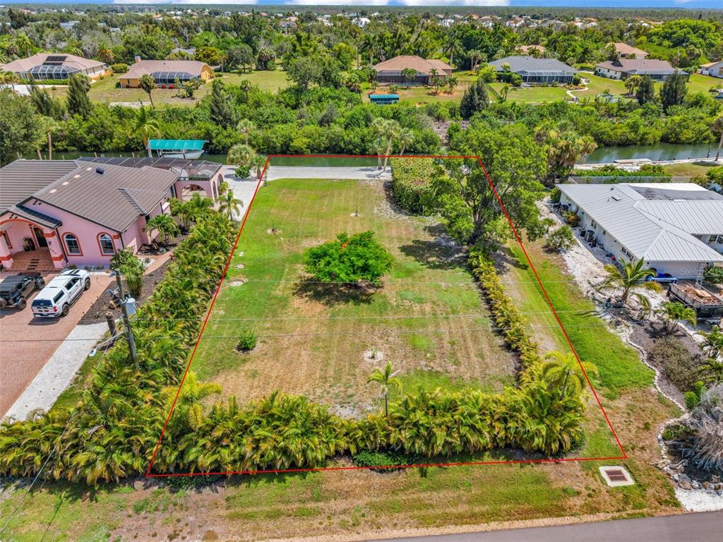 An aerial view shows a rectangular vacant lot bordered by palm trees and a canal — Lot 12 CAPSTAN DRIVE, PLACIDA, FL
