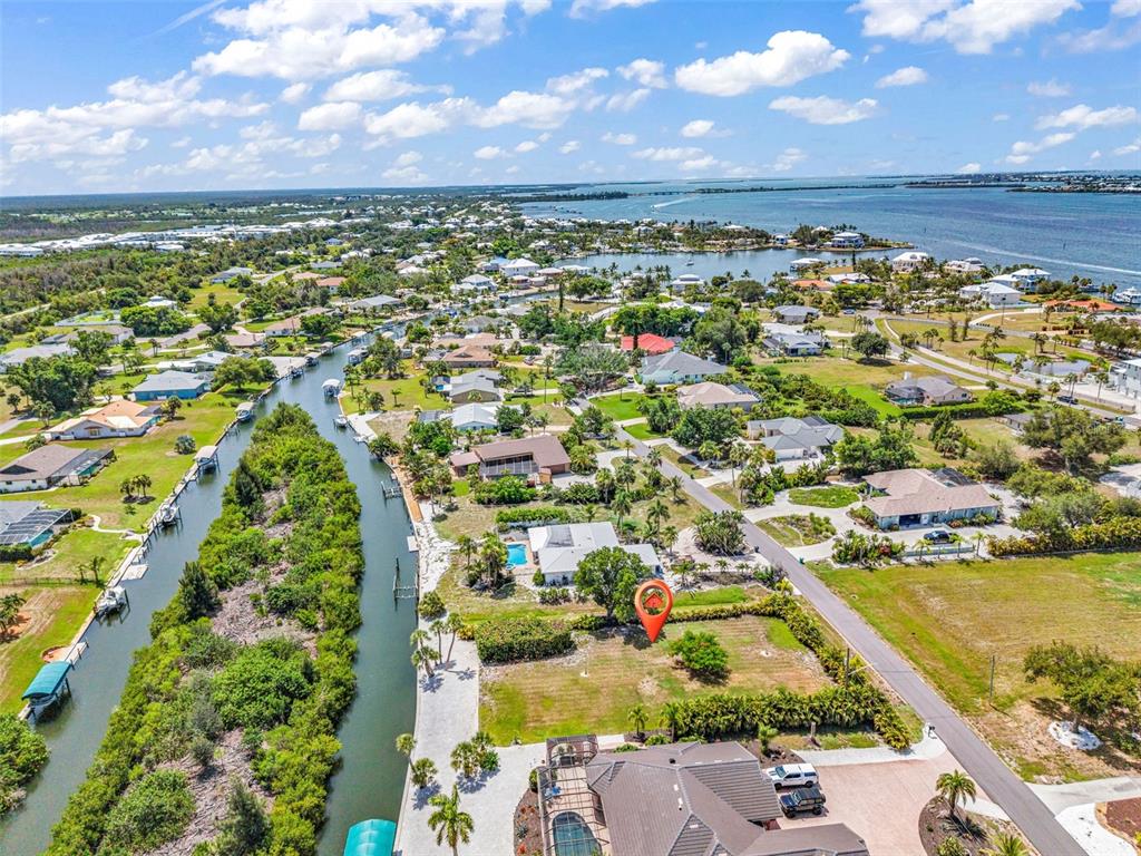 An aerial view shows a vacant waterfront lot marked with a red pin — Lot 12 CAPSTAN DRIVE, PLACIDA, FL