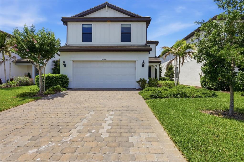 A two-story house with a white exterior, a two-car garage, and a paved driveway — 6126 BLUESTAR COURT, LAKEWOOD RANCH, FL