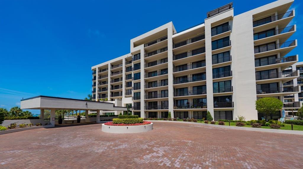 A multi-story apartment building with a paved driveway and a circular garden bed — 4 BELLEVIEW BOULEVARD UNIT 503, BELLEAIR, FL