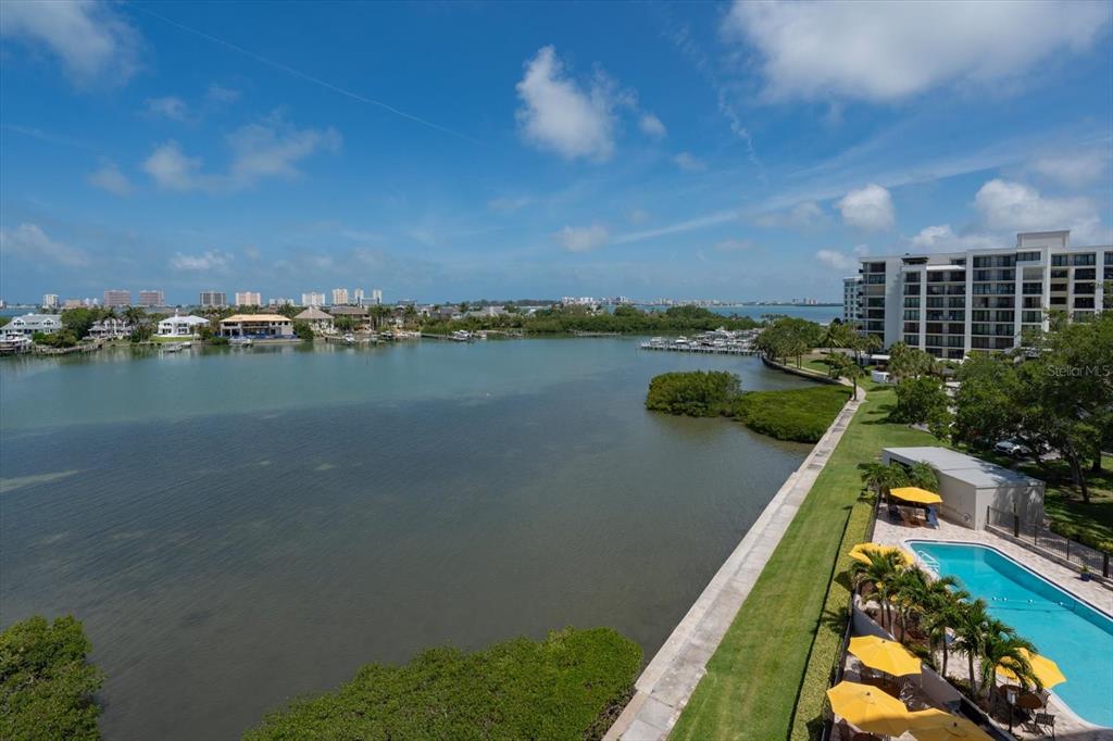 An elevated view of a coastal waterway with a swimming pool and apartment building nearby — 4 BELLEVIEW BOULEVARD UNIT 503, BELLEAIR, FL