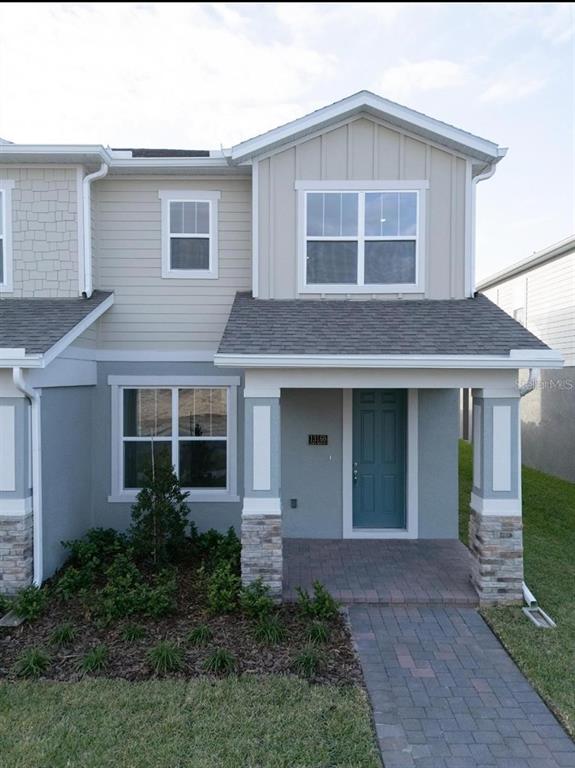An aerial view shows the exterior of two-story townhomes with gray roofs and siding — 13193 CALMING BREEZE WAY, WINTER GARDEN, FL