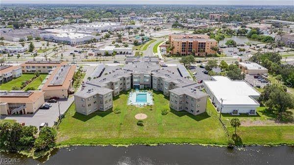 A kitchen features white cabinets, a white refrigerator, a white stove, and a double sink — 3100 HARBOR BOULEVARD UNIT 102, PORT CHARLOTTE, FL