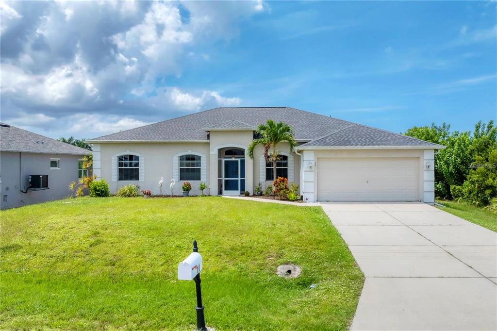 An aerial view shows a house with a gray roof, a screened-in pool, and landscaping — 11 LATEEN SAIL DRIVE, PLACIDA, FL