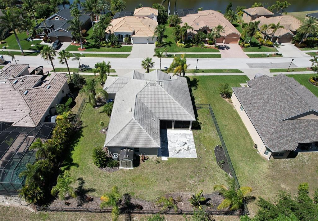 An aerial view shows a single-story house with a tiled roof, patio, and fenced yard — 5409 CONCH SHELL PLACE, APOLLO BEACH, FL