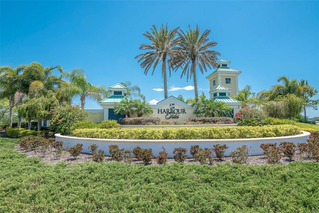 The entrance sign for Harbour Isles features palm trees and two small towers — 5409 CONCH SHELL PLACE, APOLLO BEACH, FL