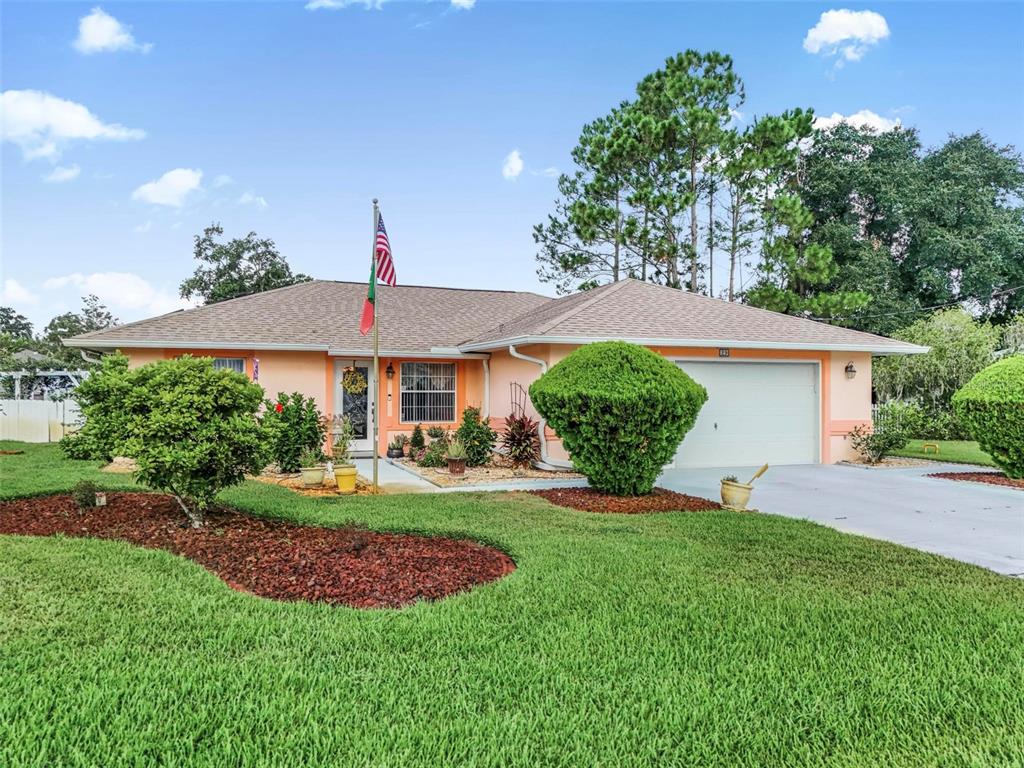 A single-story peach-colored house with a two-car garage and a front lawn — 29 WHITTLESEY LANE, PALM COAST, FL