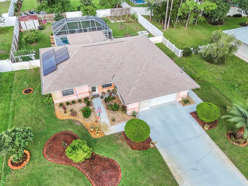 An aerial view of a single-story house with a shingled roof, solar panels, and pool — 29 WHITTLESEY LANE, PALM COAST, FL
