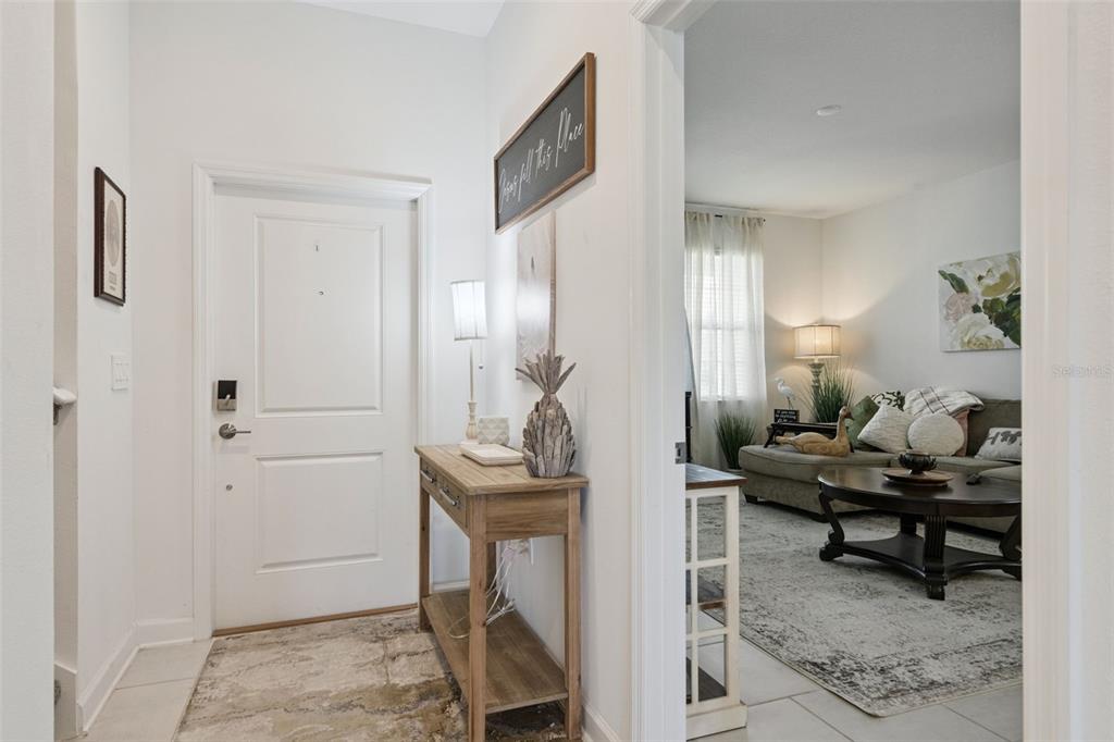An entryway with a wooden console table leads into a living room with a sofa — 4511 HILLINGDAM ROAD, DAVENPORT, FL