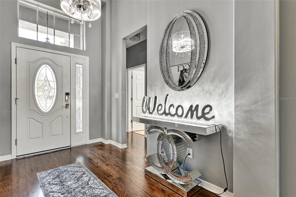 An entryway with hardwood floors, a pool table, and a decorative wall mirror display — 7514 FOREST MERE DRIVE, RIVERVIEW, FL