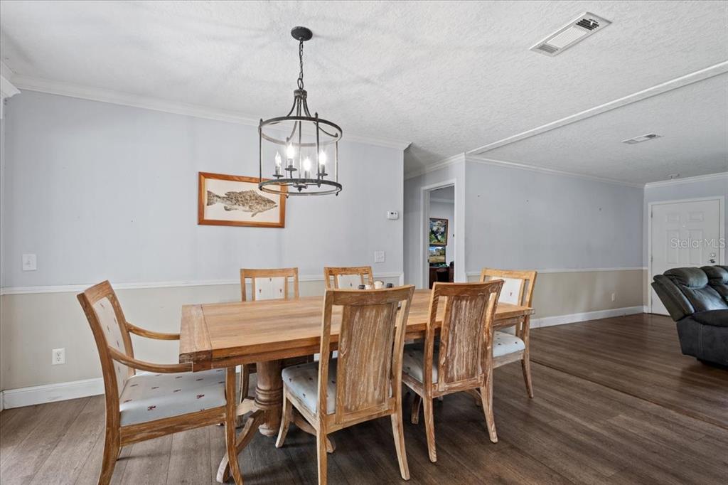 An open-concept living room and kitchen featuring a blue tray ceiling and wood flooring — 87 NE 544TH STREET, OLD TOWN, FL