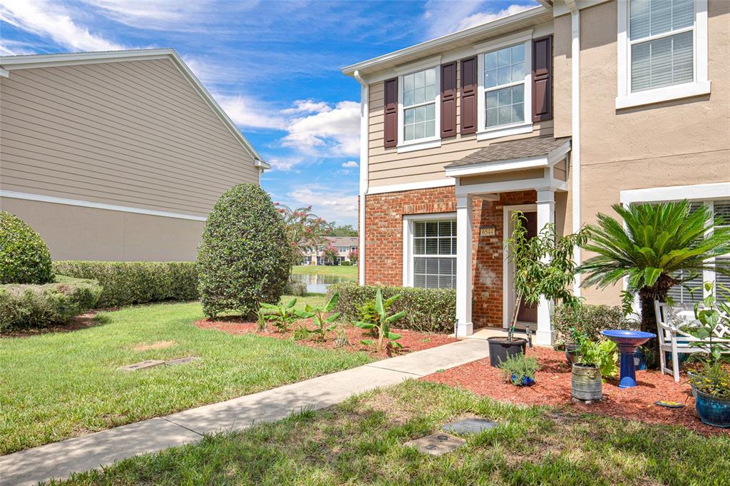 A two-story townhouse exterior features a brick facade, a covered entryway, and a landscaped yard — 6544 ARCHING BRANCH CIRCLE, JACKSONVILLE, FL