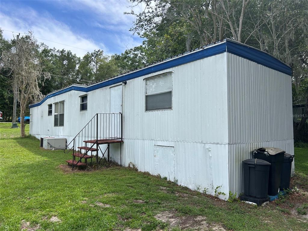 A dining area with a skull-patterned tablecloth, wooden chairs, and a desk near windows — 10945 SE 132ND PLACE, OCKLAWAHA, FL