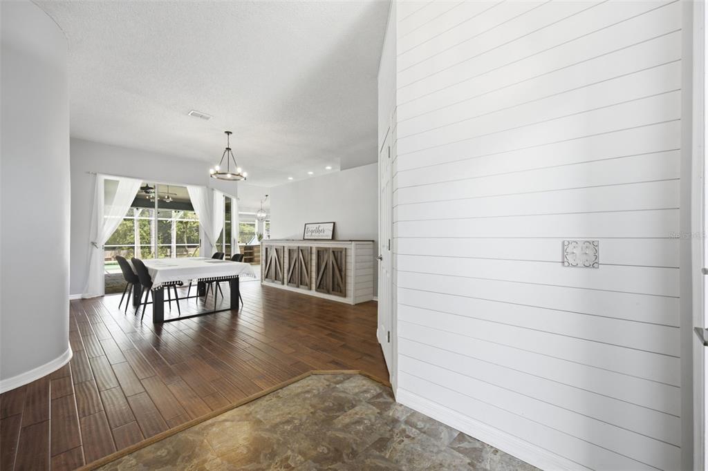 A view from a tiled entryway looking into a dining room with wood-look flooring — 28707 RALEIGH PLACE, WESLEY CHAPEL, FL
