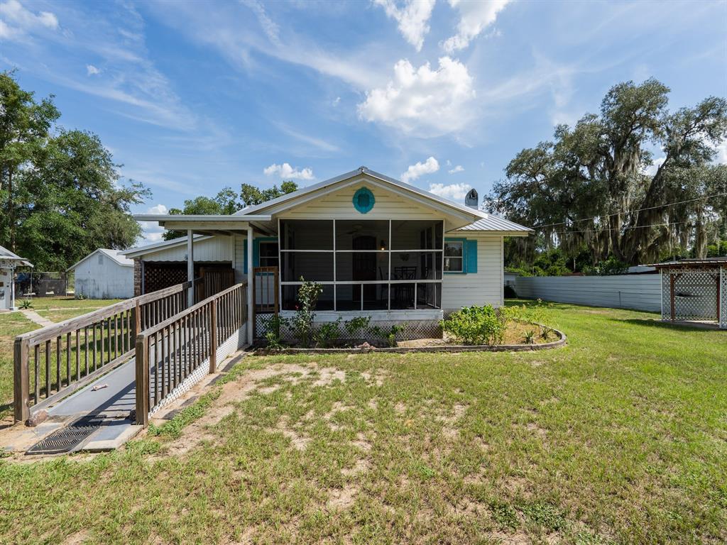 An aerial view shows a house with a metal roof surrounded by several outbuildings — 16490 E HIGHWAY 316, FORT MC COY, FL