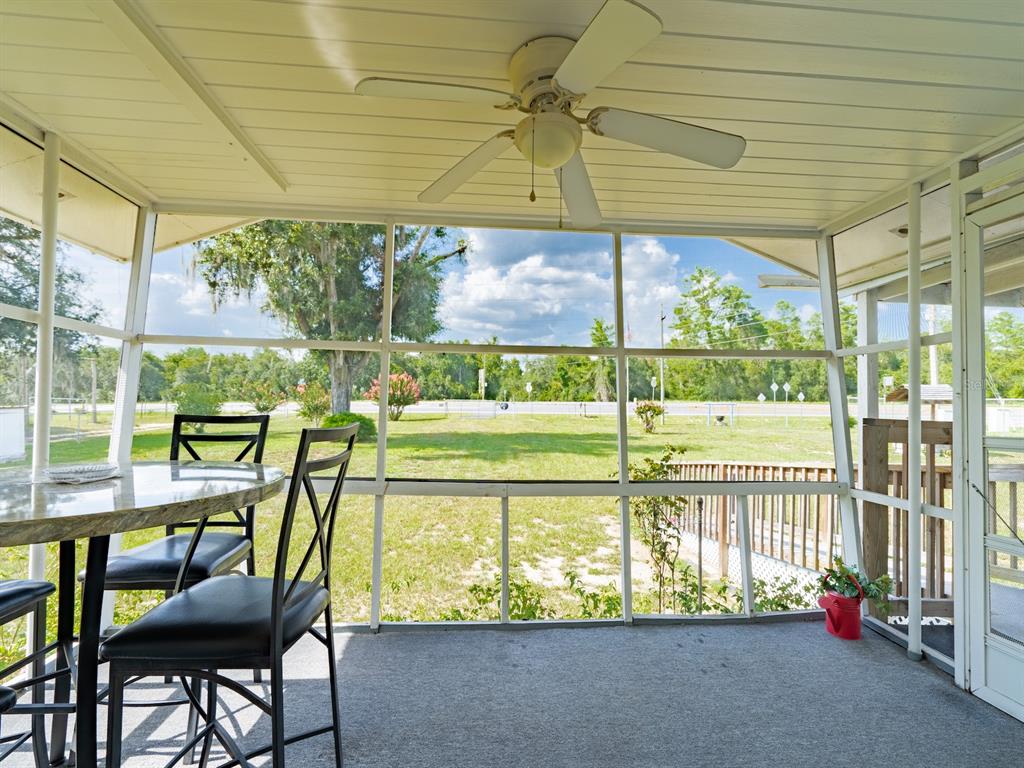 A single-story house with a metal roof, a screened front porch, and a wooden ramp — 16490 E HIGHWAY 316, FORT MC COY, FL