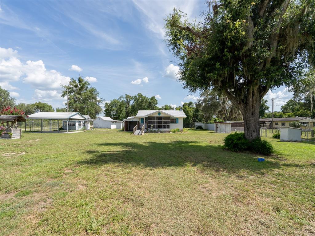 A single-story house with a screened front porch and a wooden wheelchair ramp — 16490 E HIGHWAY 316, FORT MC COY, FL