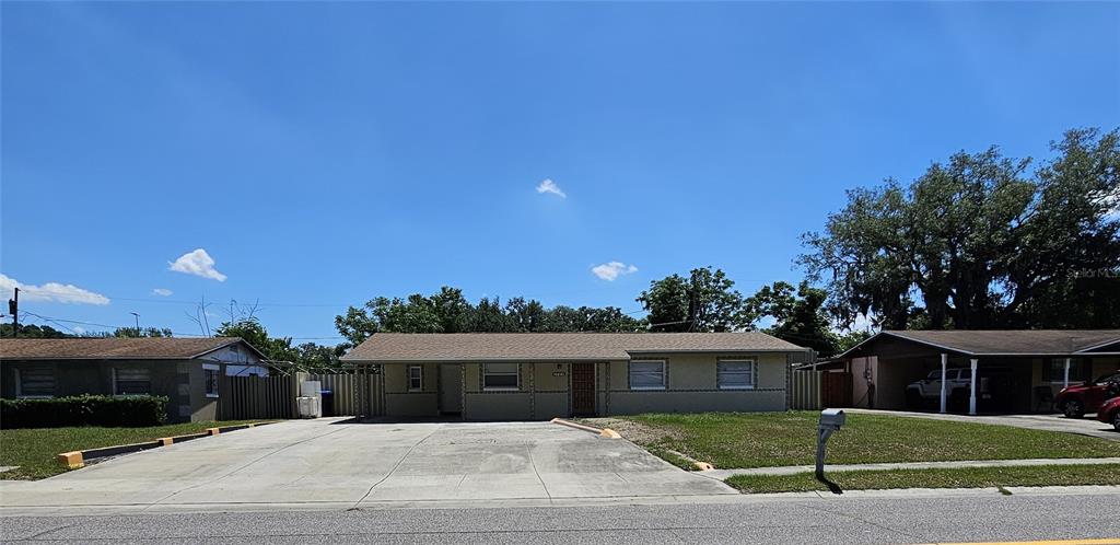 A single-story house with a concrete driveway and an attached carport under a blue sky — 3709 WESTGATE ROAD, ORLANDO, FL