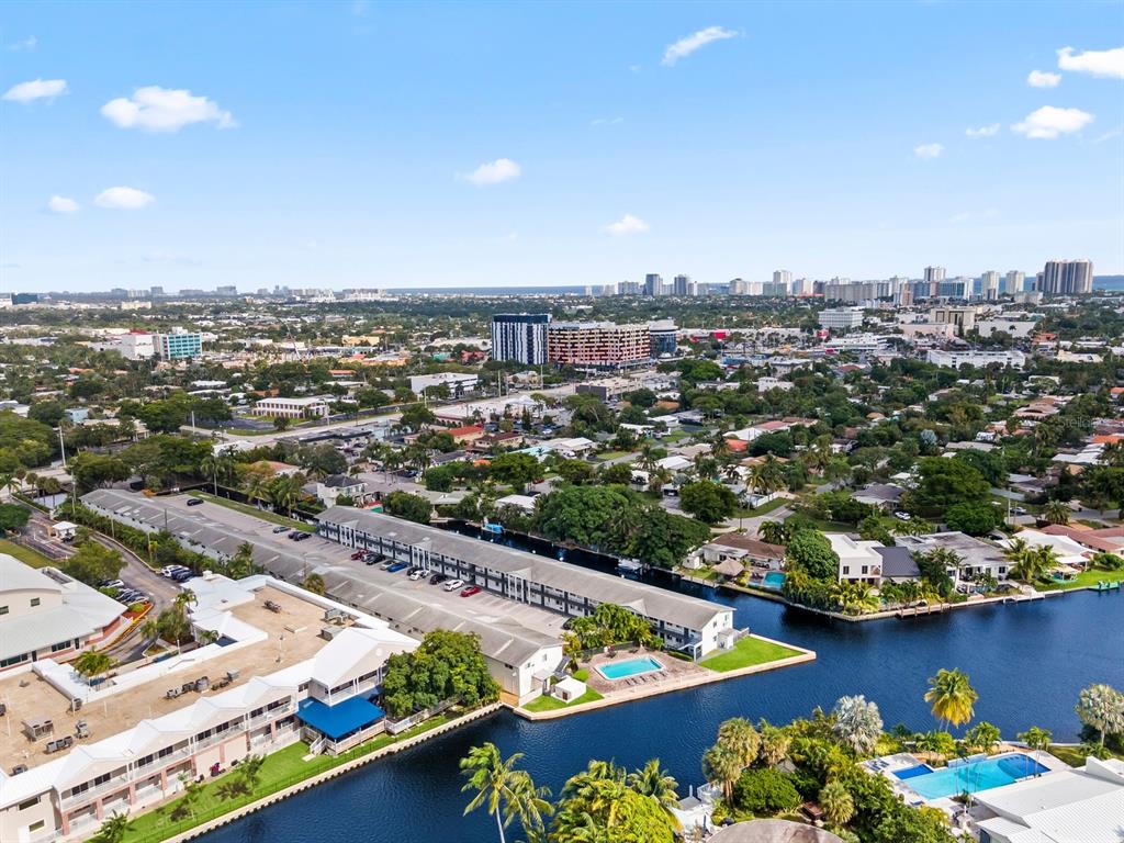 An aerial view shows a multi-story apartment complex situated along a canal in a city — 1818 E OAKLAND PARK BOULEVARD UNIT 83, OAKLAND PARK, FL